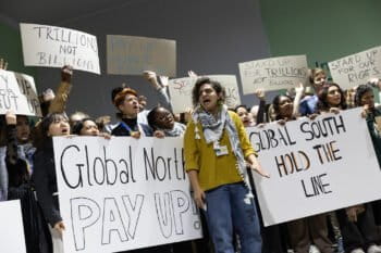 Protesters bearing signs reading "Global North, pay up" and "Global South, hold the line" outside the plenary hall during COP29, Baku, Azerbaijan. Image by Kiara Worth/UN Climate Change via Flickr (CC BY-NC-SA 2.0) https://www.flickr.com/photos/unfccc/54158868096/in/dateposted/ https://creativecommons.org/licenses/by-nc-sa/2.0/