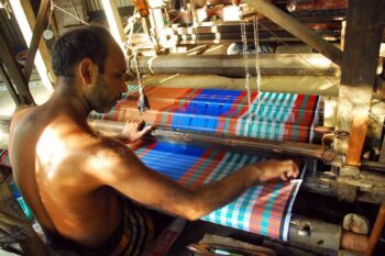 Weaving lungi by handloom at Dohar of Dhaka District. Image by Pervez Robin via Wikimedia Commons.