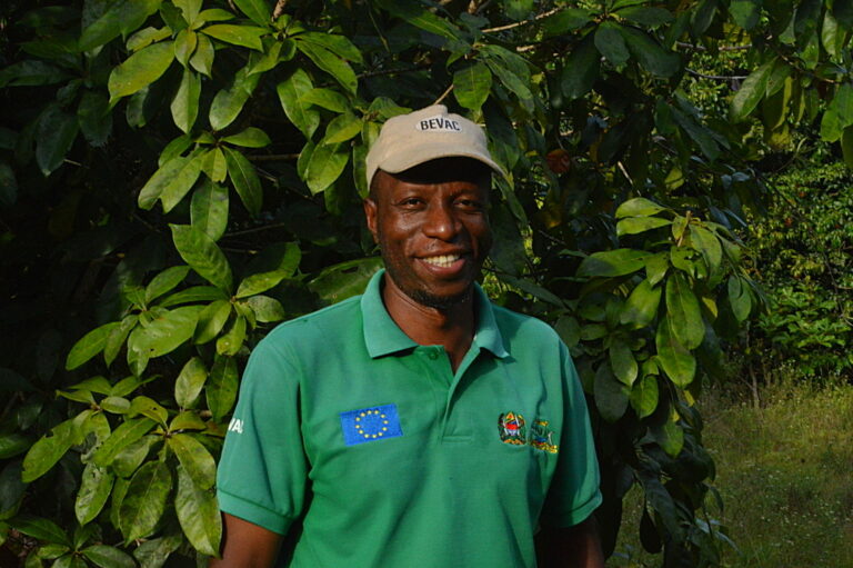 Khamis Ali Khamis, acting-chief-in-charge of Ngezi Forest Reserve, wearing a brown peaked cap and green t-shirt, smiles at the camera. Image by Ryan Truscott for Mongabay.