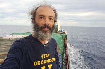 Banner image of Gianluca Grimalda on a cargo ship courtesy of Gianluca Grimalda.