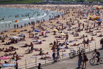Banner image of people on a Sydney beach on a hot summer day. Image by Neerav Bhatt via Flickr (CC BY-NC-SA 2.0).
