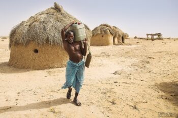A seminomadic man carries water in the Cholistan Desert.