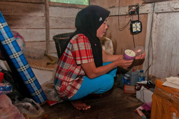 Marwati prepares a flashlight that is the main source of light in her house.