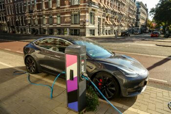 Amsterdam, a car plugged into a charging station on a city street