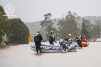 Emergency workers wading through floodwaters as they prepare inflatable boats to effect rescues near Taree, Australia, Thursday, May 22, 2025. (NSW Police via AP)
