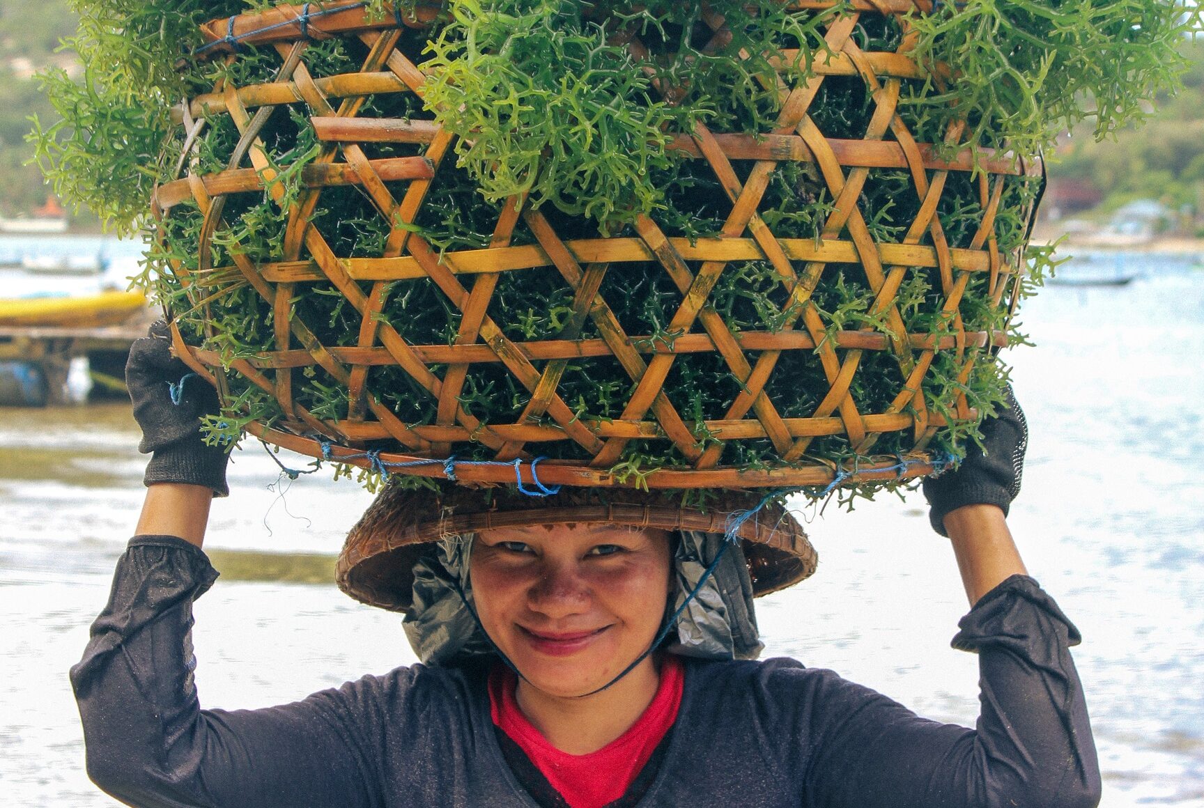 A seaweed farmer on Nusa Lembongan flashes a warm, cheeky smile as she moves through her daily harvesting routine.
