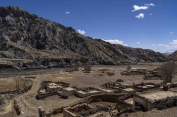 The abandoned village of Samjung, with ancient caves carved in the cliffs in the background, is seen in the Mustang region, 462 kilometers west of Kathmandu, Nepal, Friday, April 18, 2025. (AP Photo/Niranjan Shrestha)