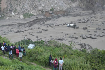 People watch the damage caused by flooding on the Bhotekoshi River 120 kilometers (75 miles) north of Kathmandu, Nepal, Tuesday, July 8, 2025. (Nepal Army via AP)