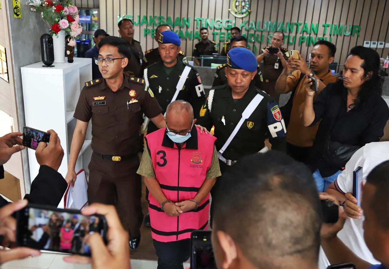 Amrullah being escorted to a prison van.