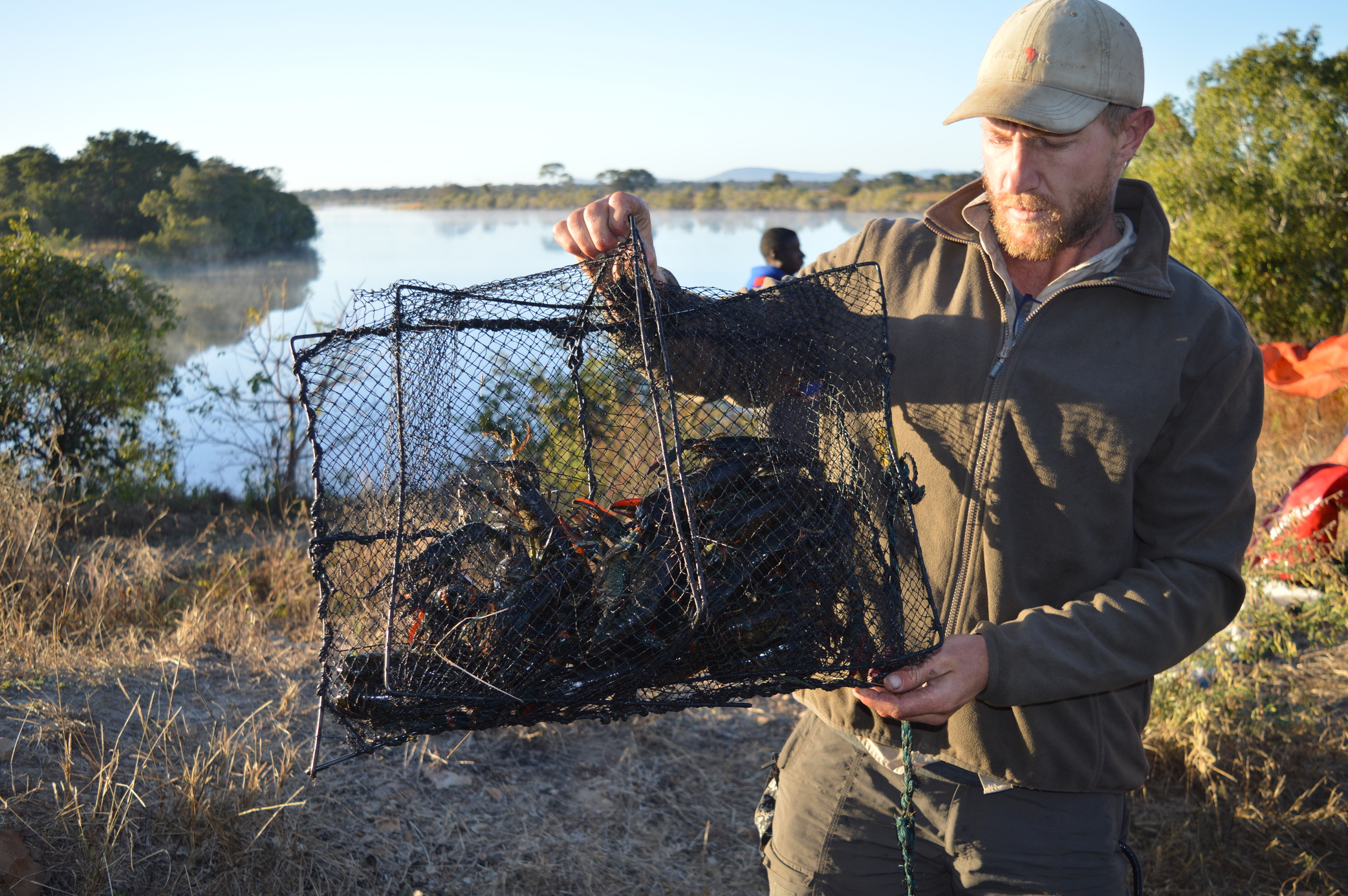 Kyle Gordon, an expedition leader with The Wilderness Project, presents the night’s catch of invasive red-clawed crayfish.