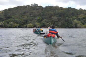 Team makes their way down the center of the river in a canoe.