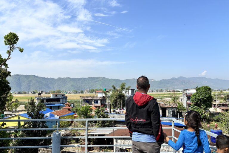 Ornithologist Hemanta Dhakal and his daughter look towards the runway of the Pokhara International Airport from their home in Majheripatan. Image by Abhaya Raj Joshi/ Mongabay.
