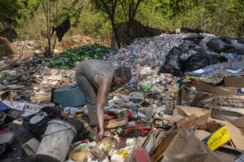 A woman collects plastic and other waste for recycling in South Africa. Less than 10% is recycled worldwide, with the rest remaining in the environment.