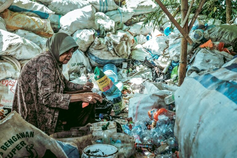 A woman sits under a tree surrounded by dry waste in East Java.
