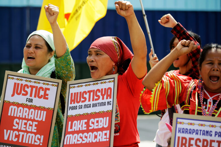 Indigenous Lumad women hold slogans during a rally outside a military headquarters in the Philippines in 2018