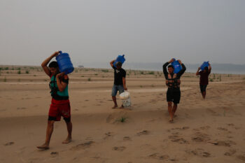 Residents transport drinking water from Humaita to the Paraizinho community, along a dry part of the Madeira River, a tributary of the Amazon River, amid a drought, Amazonas state, Brazil, Sep. 8, 2024. (AP Photo/Edmar Barros, File)
