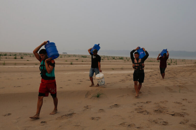 Residents transport drinking water from Humaita to the Paraizinho community, along a dry part of the Madeira River, a tributary of the Amazon River, amid a drought, Amazonas state, Brazil, Sep. 8, 2024. (AP Photo/Edmar Barros, File)