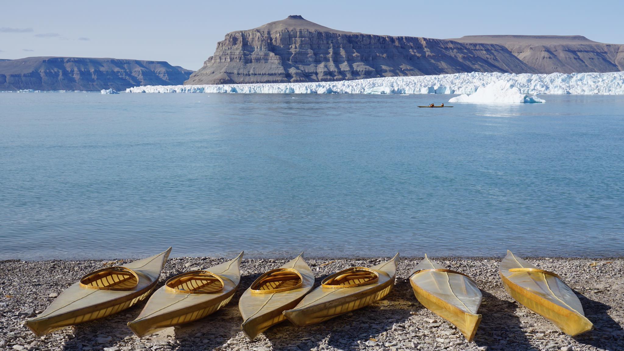 Traditional kayaks lined up along the shore of Tallurutiup Imanga (Lancaster Sound) National Marine Conservation Area in Nunavut, Canada, in 2019. Image courtesy of ICC.