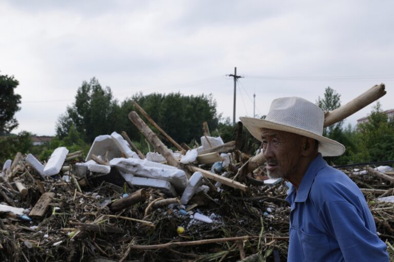 Damaged road littered with broken tree branches after a heavy rain in the Miyun district in the outskirts of Beijing, China. Image © Mahesh Kumar A./AP.