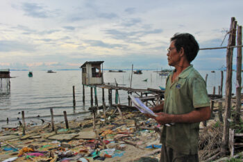 Resident Huỳnh Ngọc Vân at his old seaside home, surrounded by demolished houses cleared for the project, late April 2025.