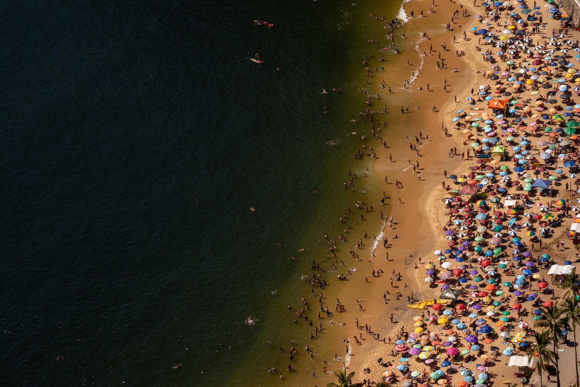 A crowded beach in Rio de Janeiro, Brazil. Studies link sunscreen pollution to tourism activities due to the products washing off people’s bodies into coastal waters. Image via Pixabay.