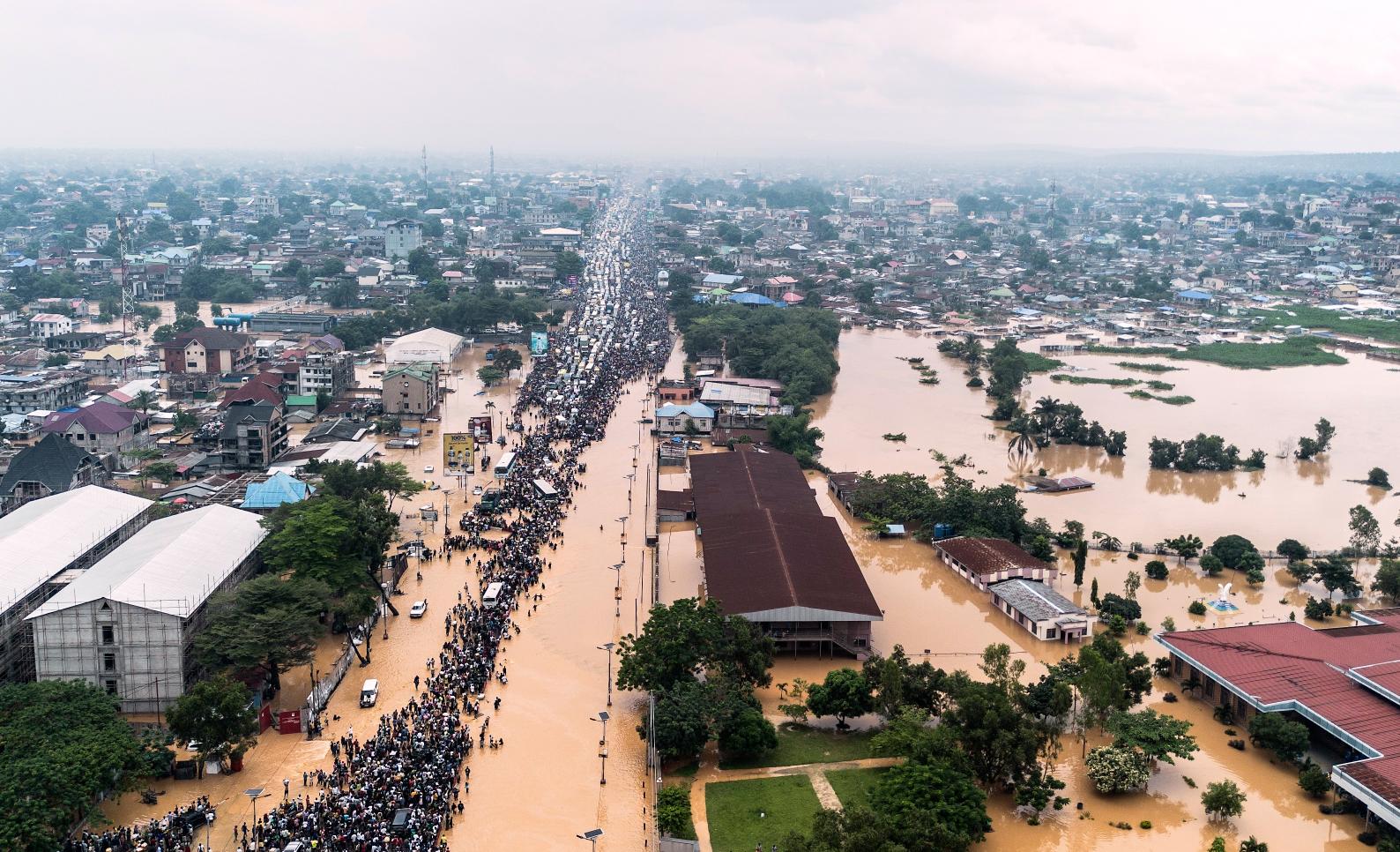 People walk through the flooded streets of Kinshasa, Democratic Republic of Congo, April 6, 2025. Photo by AP Photo/Samy Ntumba Shambuyi