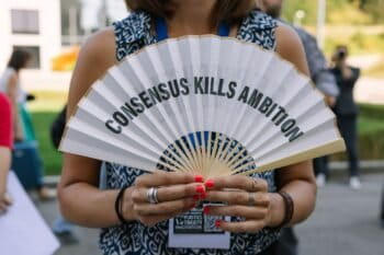 A protestor sums up INC-5.2’s failure with the slogan: “Consensus kills ambition.”