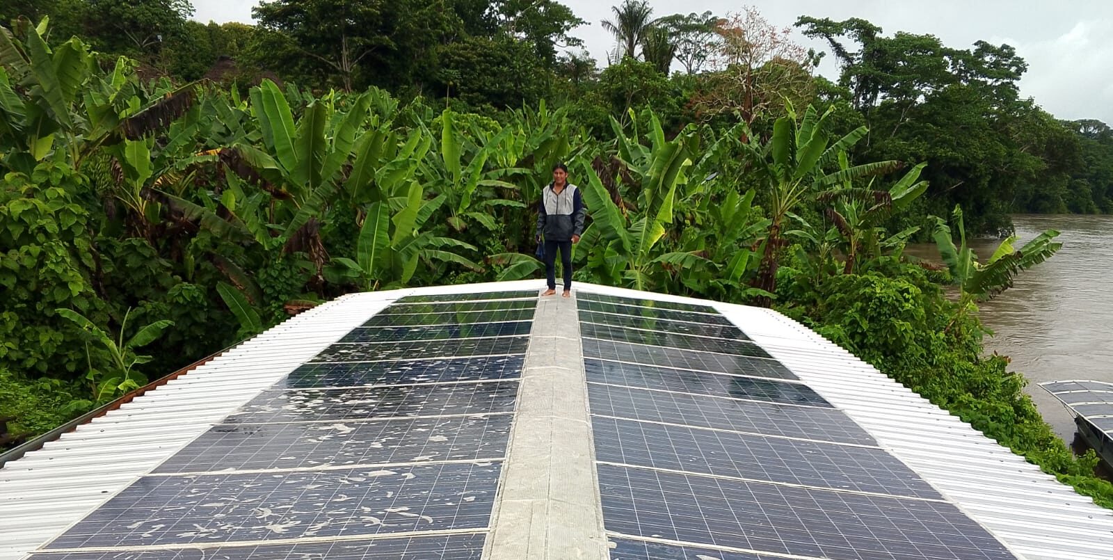 Santiago Pakunt performing maintenance on the solar panels at the Sharamentsa Solar Center. Image by Roberto Peas.