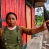 A female member of the Charip territorial monitoring group standing outside a monitoring post holding a traditional spear. Image courtesy of Maria Goretii/Convoca.