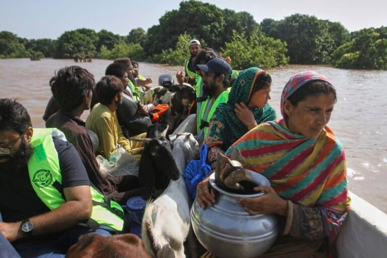Volunteers evacuate villagers from a flooded area following heavy rains and raising water in rivers, in Muzaffargarh, Pakistan, Thursday, Sept. 4, 2025. (AP Photo/Asim Tanveer)