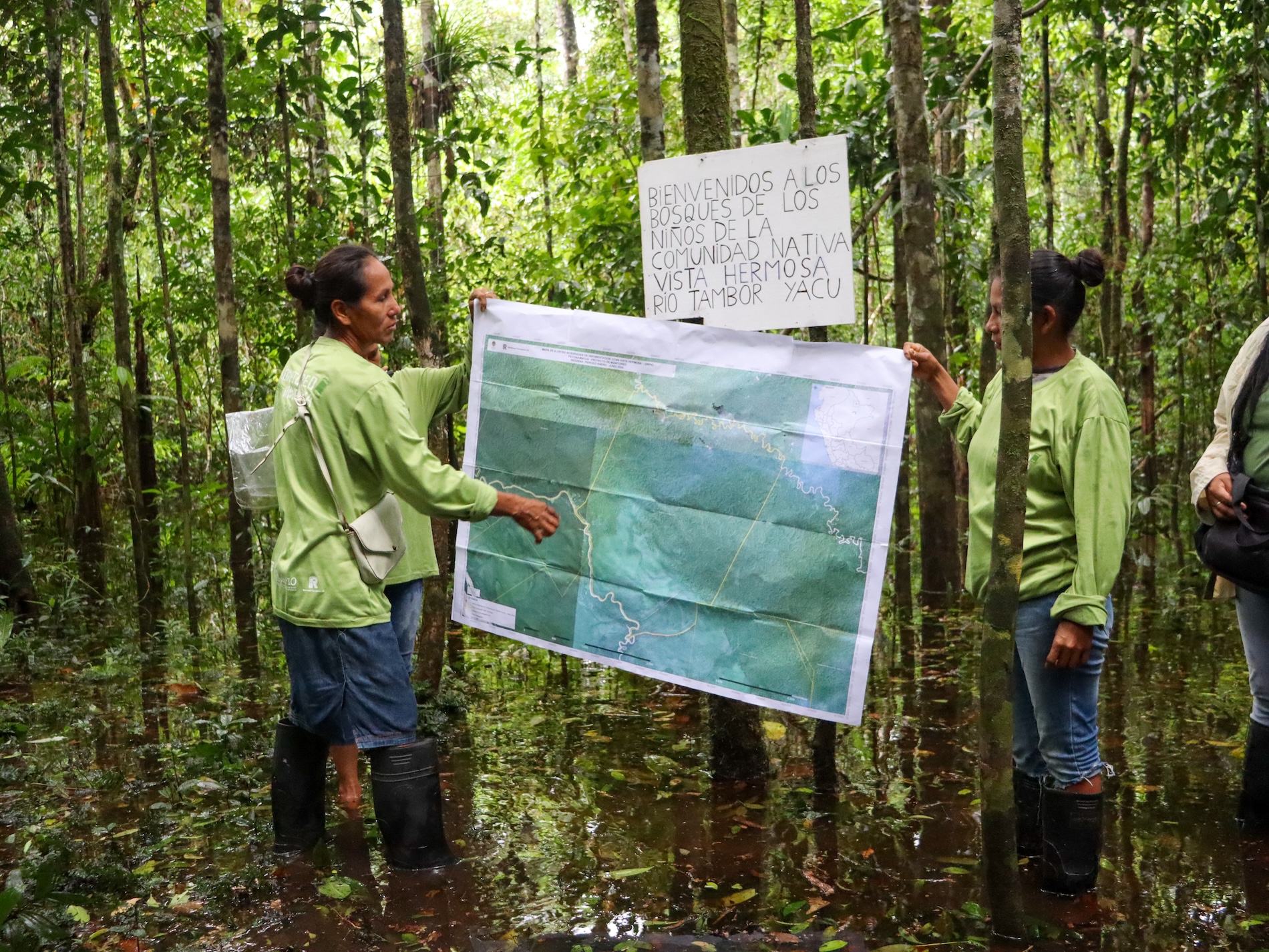 Monitors from the Vista Hermosa community in Alto Napo study a map showing the boundaries of their territory. Image courtesy of Marita Domper/ORPIO.