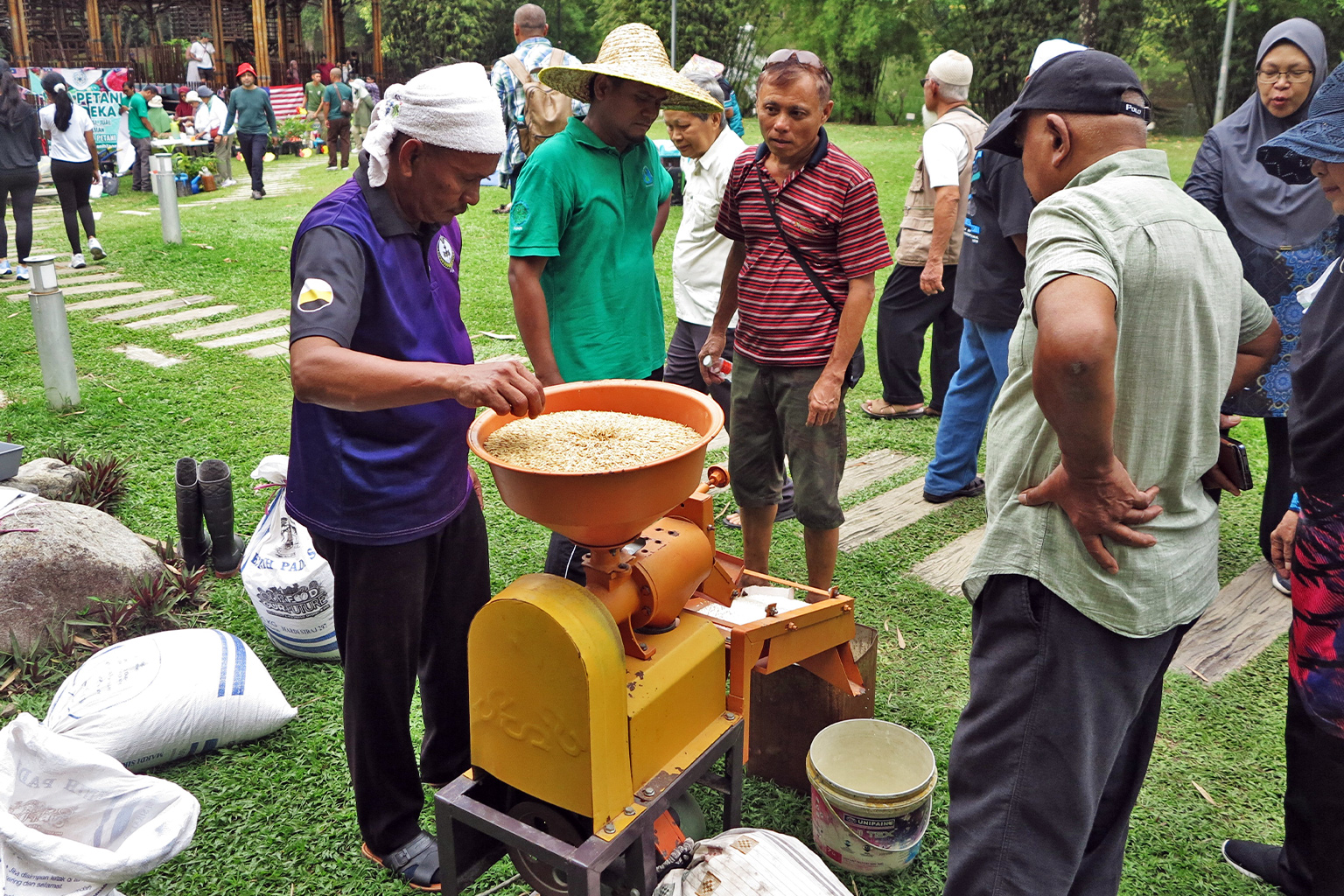 Independent farmers milling rice at a mini carnival in Perdana Botanical Garden, Kuala Lumpur.