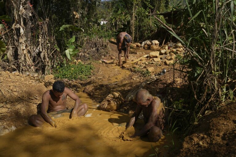 Miners pan for gold at a gold mine in El Callao, Bolivar state, Venezuela, Friday, April 28, 2023. Miners pan for hours in ponds where standing water fosters mosquitos that transmit diseases, such as malaria and dengue fever. Photo by: AP Photo/Matias Delacroix.