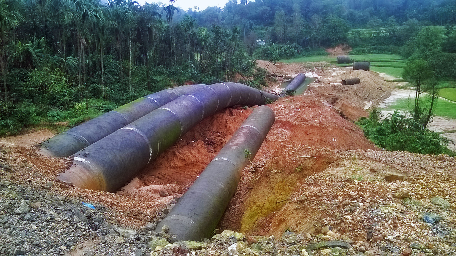 Yettinaholé pipeline remains scattered across wet monsoon soil during its construction.