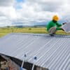A worker of a sustainable solutions company performs maintenance work on a solar panel on a roof on the island of Sumba in Indonesia.
