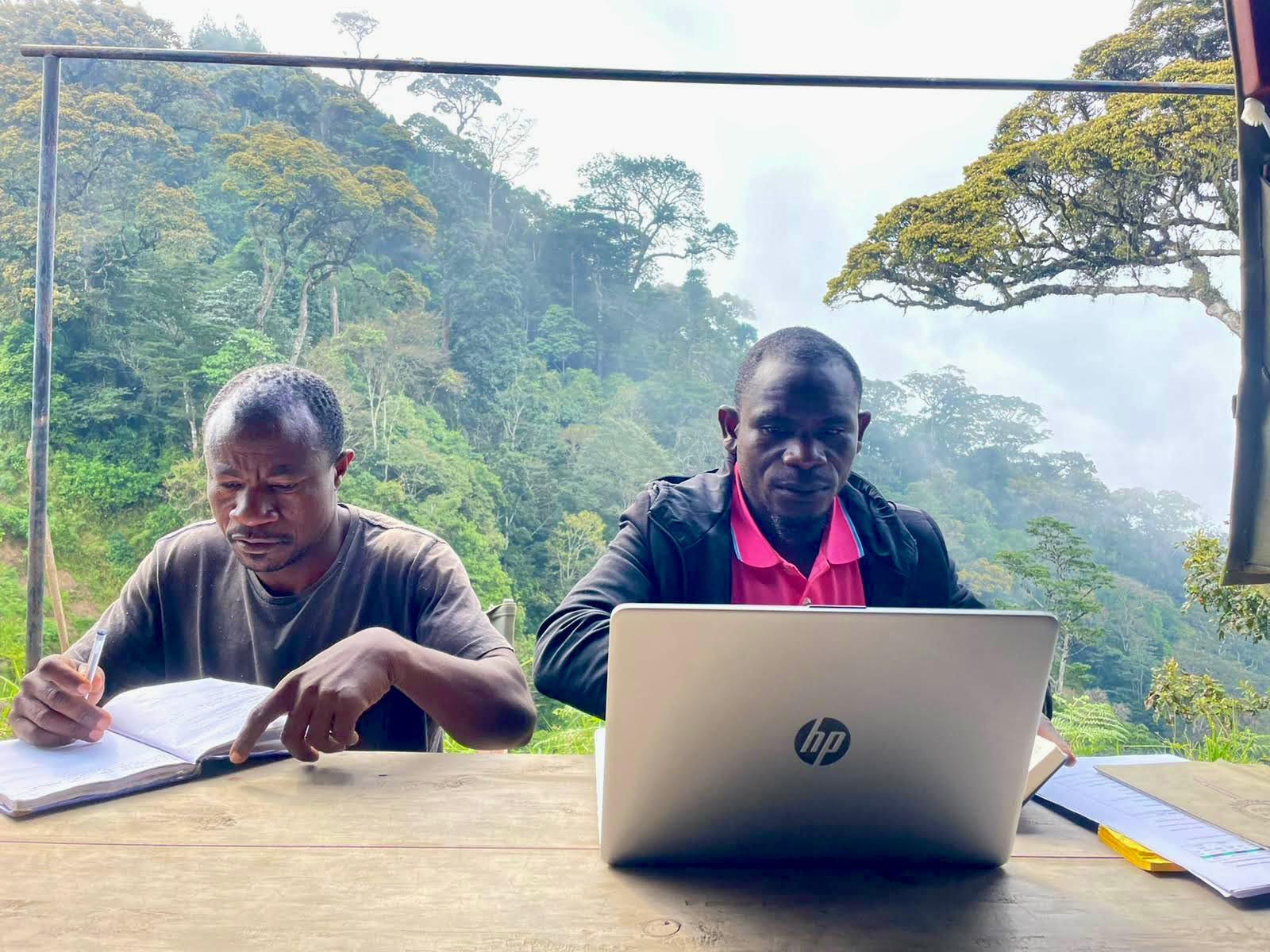 Aloyce Mwakisoma, left, and Pastory Njekela, former nurseries manager at Udzungwa Corridor, working on plans for future seed collections for the reforestation project. Image courtesy of Andrea Bianchi.