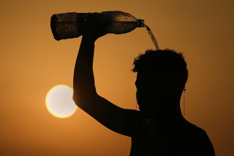 After a game of beach footvolley on a sweltering hot day in Beirut, Lebanon, a man cools off by pouring water on himself.