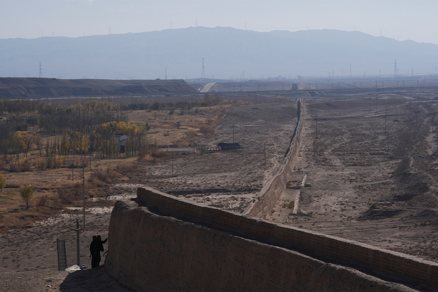 Visitors examine an ancient wall near Jiayu Pass, a strategic point of the Great Wall of China in northwestern Gansu province. As with many other World Cultural Heritage sites, the Great Wall is threatened by climate change.