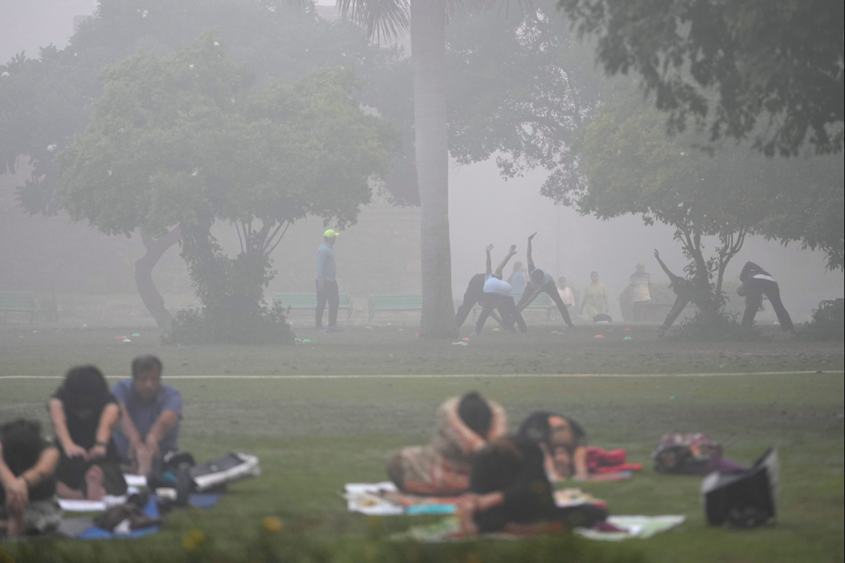 People do yoga early morning at the Lodhi garden as a thick layer of smog envelopes New Delhi in 2024. Once again, the city faces dangerously high levels of air pollution — an example of the sort of environmental challenge that young journalists today experience directly, rather than as a distant problem. Image by AP Photo/Manish Swarup, File.