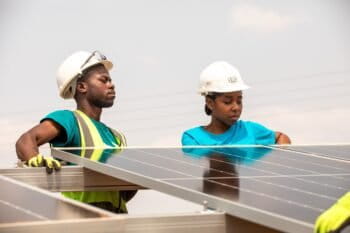 Technicians in Zimbabwe inspect solar panels. Image © UNDP Zimbabwe.