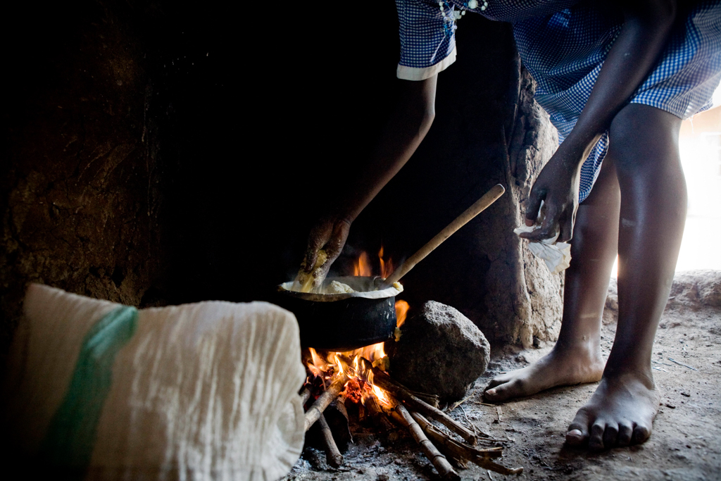 A young girl preparing a meal for herself and her brother during the lunchbreak in Kenya. Image © FAO/Sarah Elliott.