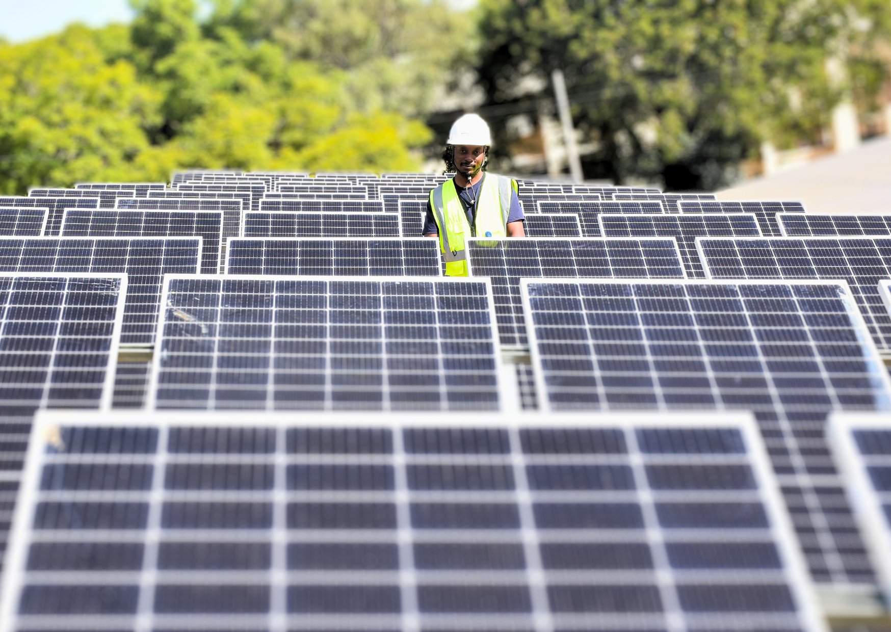 A technician inspects an array of solar panels in Lilongwe, Malawi. Image © Florence Leysen/UNDP Malawi via Flickr.