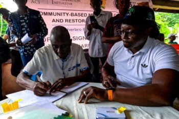 Thomas J.K.L. Koroma II, paramount chief of Sitta Chiefdom, signs the revenue-sharing carbon agreement. Image courtesy of Namati.