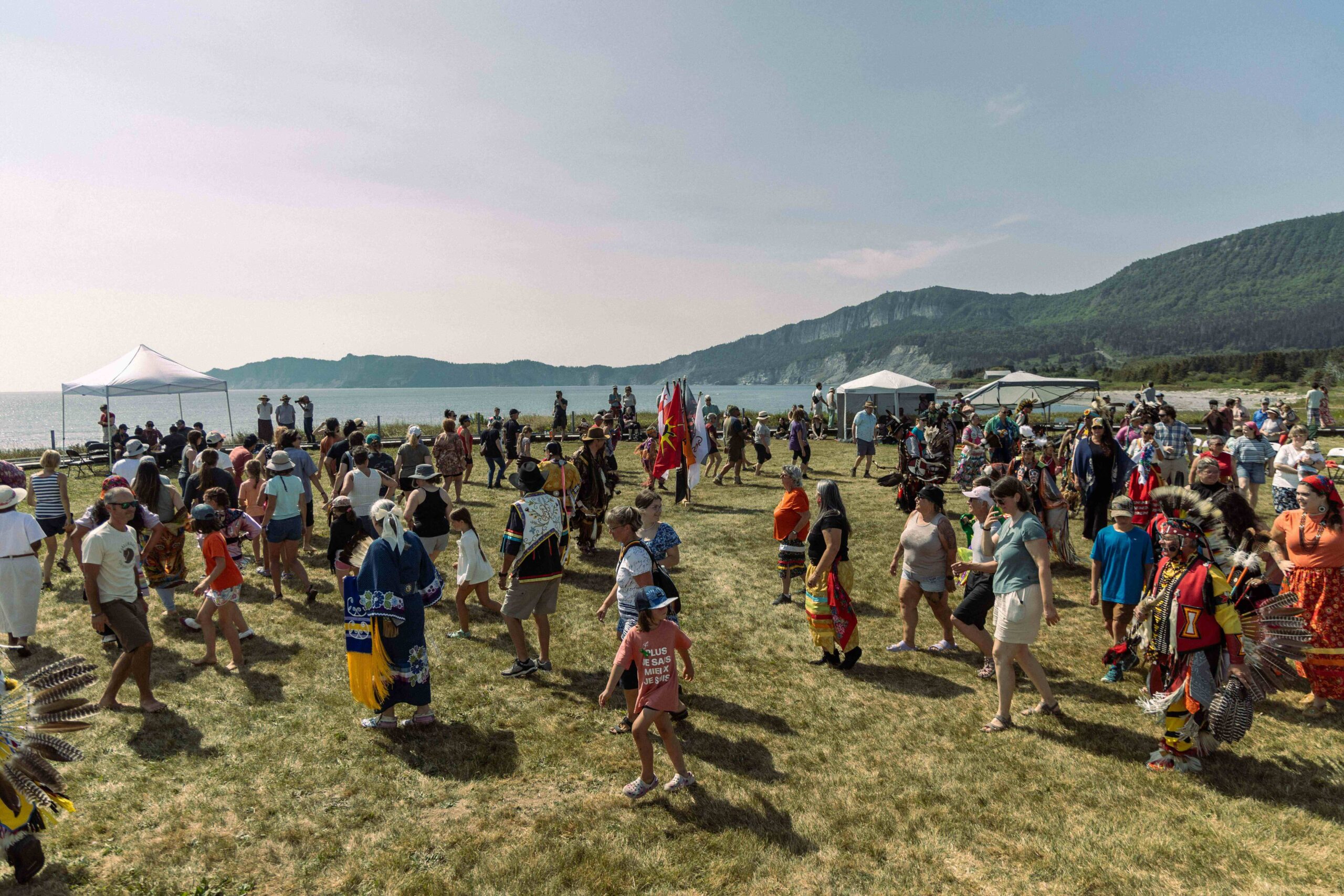 Mi'kmaq people of eastern Canada taking part in a Mawiomi, or powwow, near the river. Image by Boris R. Thebia.