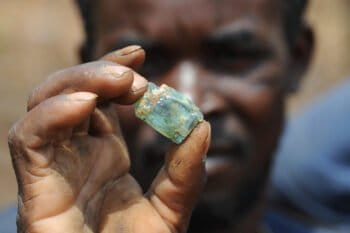 An artisanal miner holds up a fragment of copper-bearing ore at the Lukuzi.