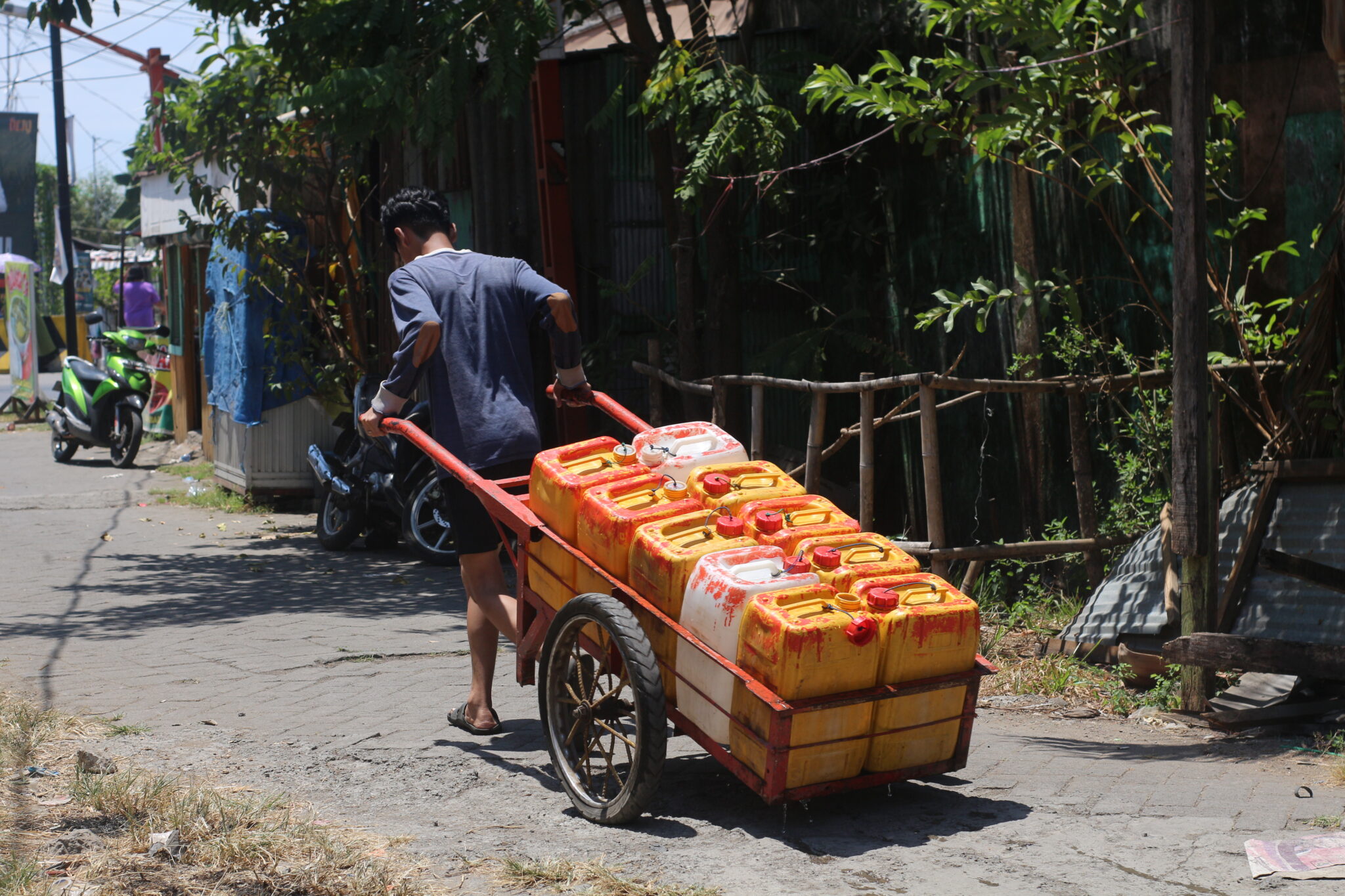 A resident pulls a cart carrying clean water to meet daily needs.