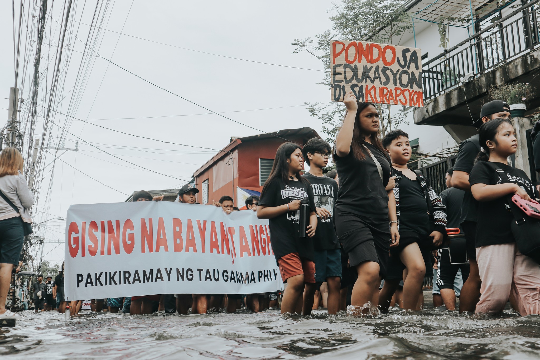 Hagnoy residents march amid floodwaters as part of their protest walk against corruption.