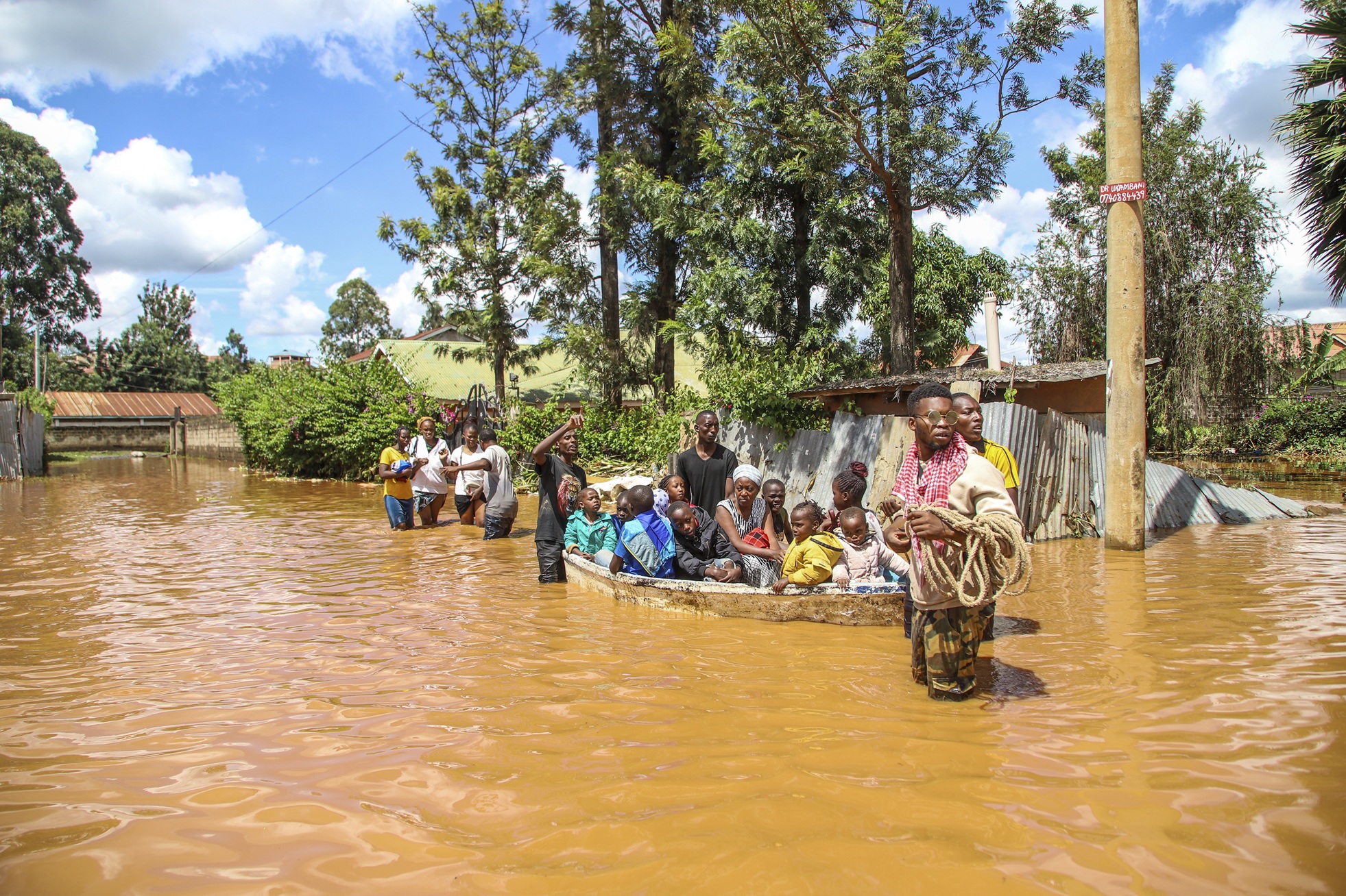 A family uses a boat after fleeing floodwaters that wreaked havoc in the Githurai area of Nairobi, Kenya, April 24, 2024.