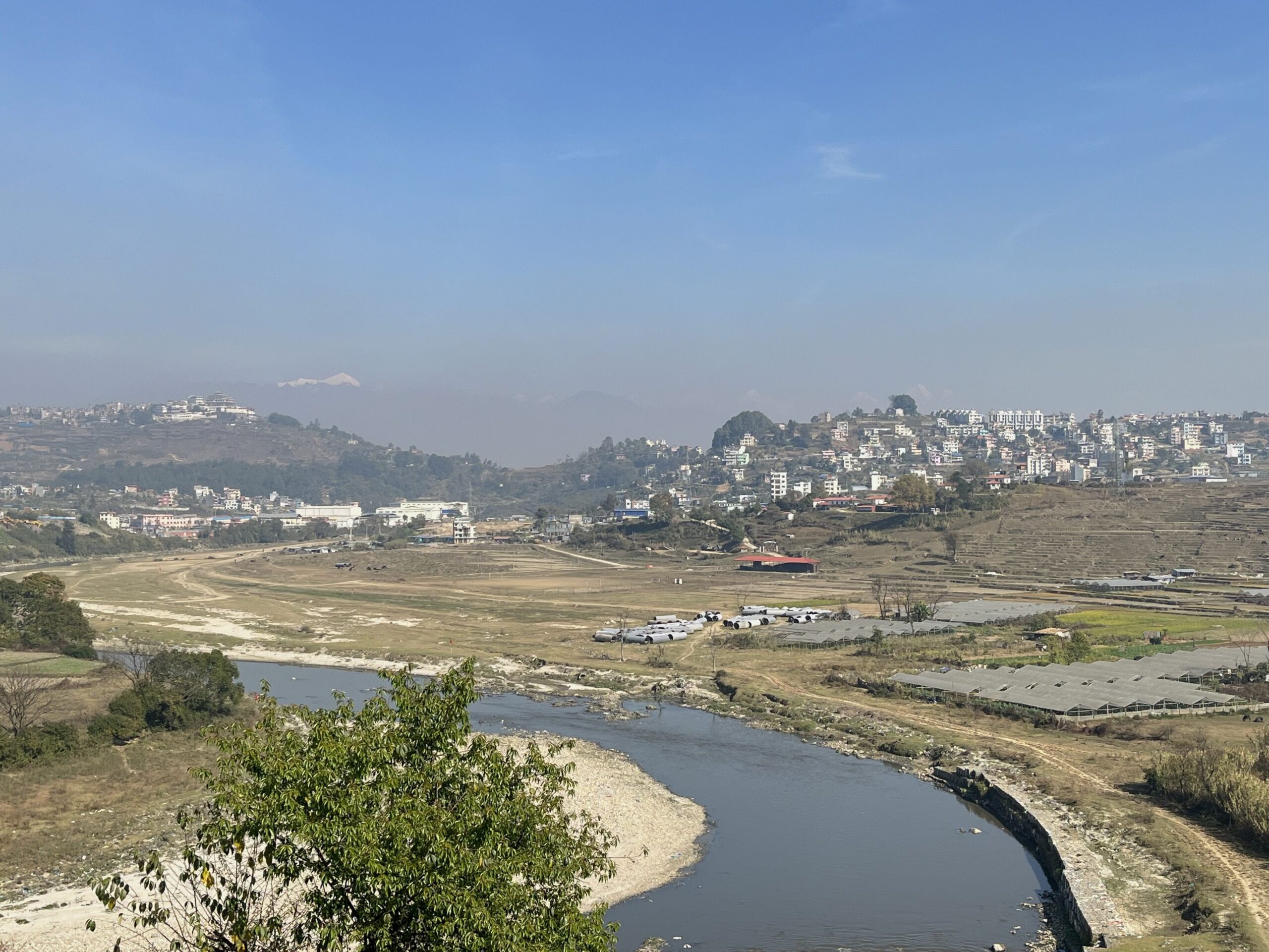 The flat land across the Bagmati River bulldozed to make way for the fast track, with the army camp at a distance. Photo Bibek Bhandari. jpg-min