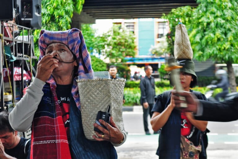 Rainim Purba gives a speech and attempts to climb a fence during a protest urging the ministry of environment to revoke PT DPM’s environmental permit in Jakarta, May 2025.